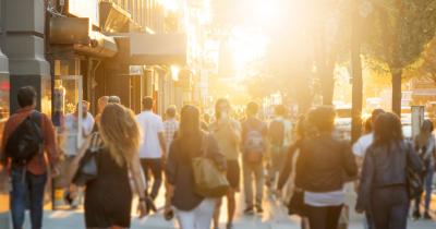 People walking down street at sunset